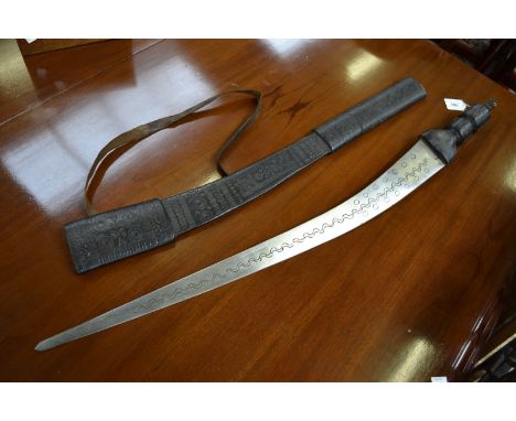 A Sudanese sword, the blade engraved with foliate curves, tooled leather scabbard