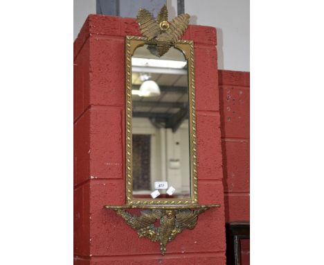 A gilt framed wall mirror with serpentine shelf, flowering fern pediment, arched glass.