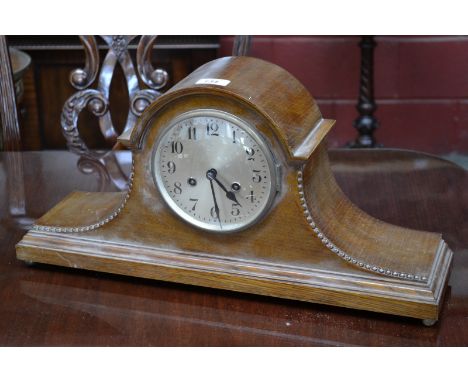 An early 20th century light oak Napoleon hat mantel clock, twin winding holes, Arabic numerals, 56cm wide