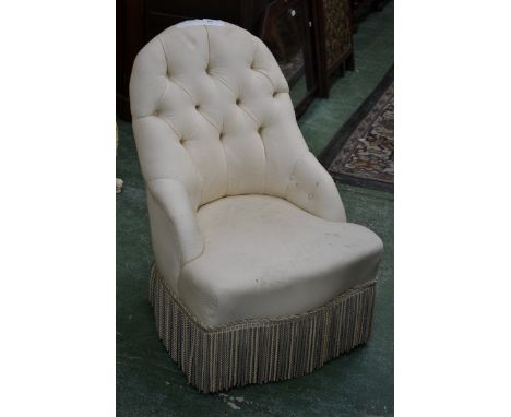 A Victorian style deep-buttoned nursing chair, stuffed-over upholstery, turned legs, ceramic casters
