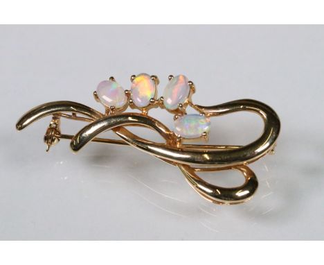 14ct gold and opal brooch. The brooch set with four oval opal cabochons set within a open work mount. Marked 585 to verso. Me