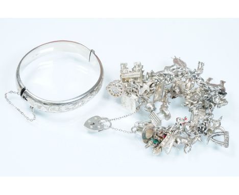 Silver charm bracelet having a curb link chain and padlock clasp with 28 assorted silver and white metal charms, together wit