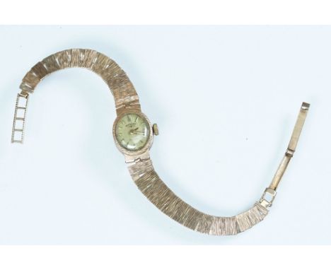 Mid Century 9ct gold Rotary ladies cocktail watch having an oval gilt face set to a textured gold bracelet strap. Clasp hallm