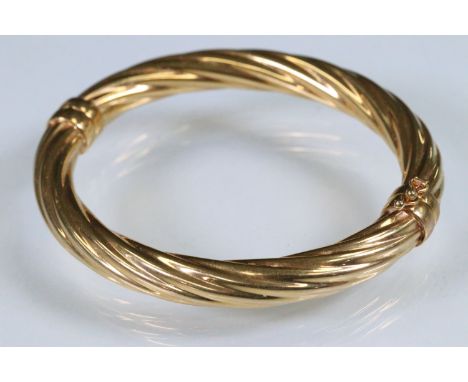 9ct gold hinged bangle bracelet of twisted design. Italian hallmark to inner bracelet. Measures 6cm wide.