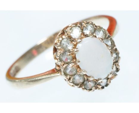 9ct gold and diamond cluster ring. The ring being set with an oval opal cabochon with a halo of round cut diamonds. Hallmarke