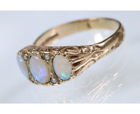 9ct gold and opal three stone ring. The ring being set with three oval opal cabochons with pearl accent stones set within a s