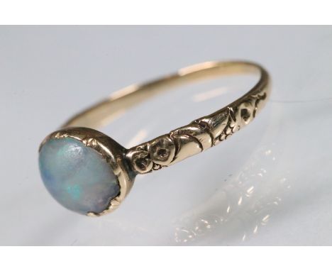 George III opal ring being bezel set with an oval opal cabochon with floral chased band. Unmarked, tests indicate gold. Size 