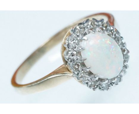 9ct gold opal and diamond cluster ring. The ring being set with an oval opal cabochon with a halo of round single cut diamond