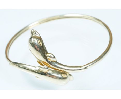 14ct gold dolphin bangle bracelet having dolphin formed terminals. Marked 585. Measures 6cm wide.