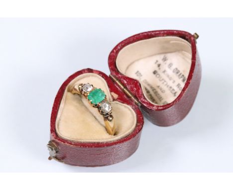 Victorian 18ct gold emerald and diamond three stone ring. The ring being set with a rectangular step cut emerald flanked by t