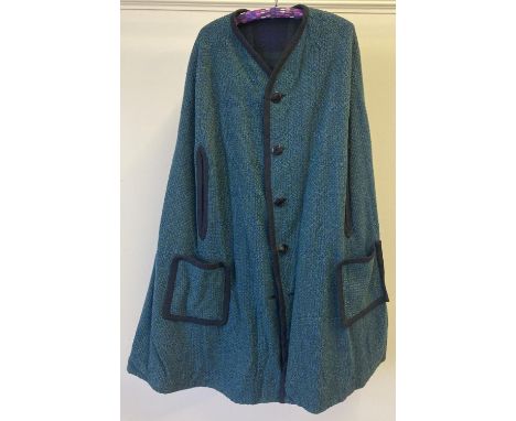 A vintage reversible wool mix cape with green and blue fleck tapestry style material to one side with front pockets and butto