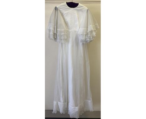 A vintage 1970's white empire line wedding dress with tiered polyester chiffon angel sleeves. 