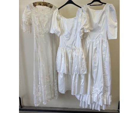 3 vintage 1980's short sleeved wedding dresses. A drop waist dress with frill and bow detail, a 2 tier satin dress with rose 