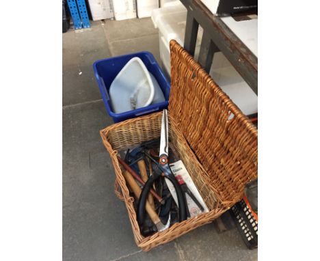 A WICKER BASKET WITH GARDEN TOOLS