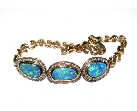 A bracelet with three broadly asymmetric oval black boulder doublet settings, each with brilliant cut diamonds, the centrepie