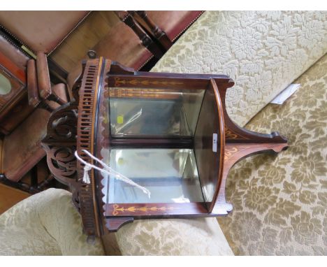 An Edwardian inlaid rosewood hanging corner shelf, the fret carved top over a galleried shelf and mirror backed shelf, 68 cm 