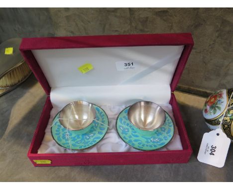 A pair of enamel cups and saucers 