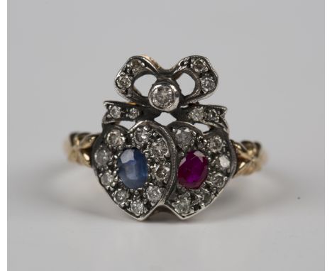 A gold, ruby, sapphire and diamond twin heart cluster ring, each heart mounted with either an oval cut ruby or an oval cut sa