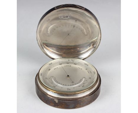An Edwardian silver cased desk barometer, the silvered dial with mercury thermometer, the cylindrical case with hinged lid, l