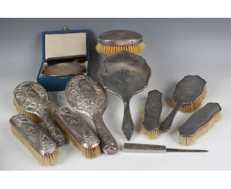 A George VI silver mounted engine turned four-piece dressing table set, comprising hand mirror, hairbrush and two clothes bru