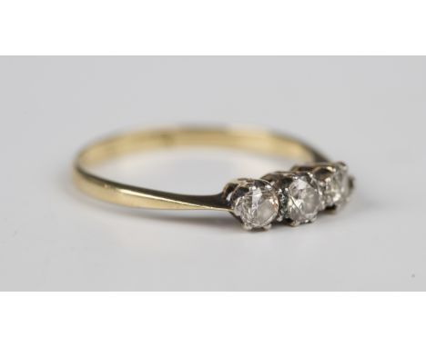 A gold, platinum and diamond three stone ring, claw set with a row of circular cut diamonds, detailed '18ct &amp; Pt', weight