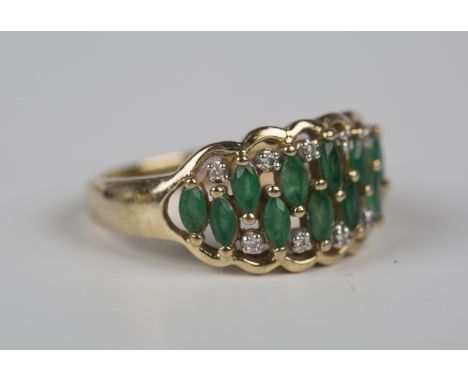 A 9ct gold, emerald and diamond ring, mounted with marquise shaped emeralds and circular cut diamonds in a pierced openwork d