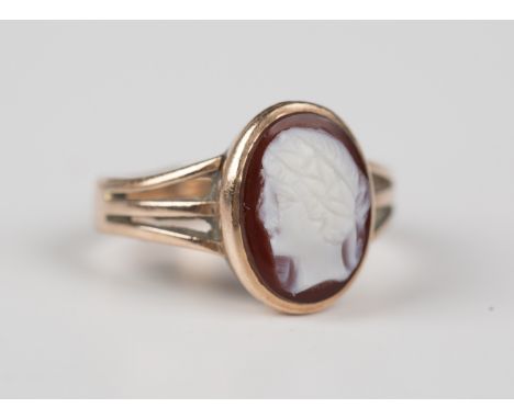 A 9ct gold and banded agate oval cameo ring, carved as a classical portrait between split shoulders, weight 3.4g, ring size a