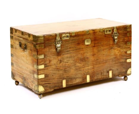 A camphor wood trunk, brass bound with carrying handle, on wheels, 114cm wide, 55cm deep, 59.5cm high