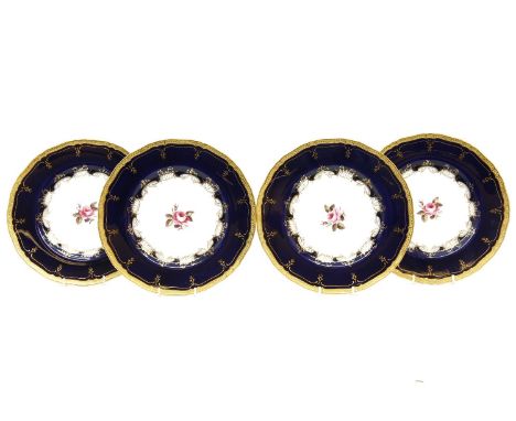 Four Royal Worcester cabinet plates, the central hand painted roses within a cobalt blue and gilded border