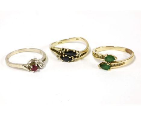 A gold pear shaped two stone emerald crossover ring, with diamond set shoulders, 2.25g, a gold two stone sapphire and diamond