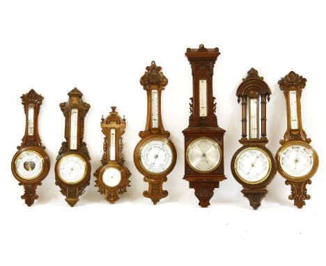 A Nagretti & Zambra walnut cased aneroid barometer, the silvered dial with thermometer above, together with six further anero
