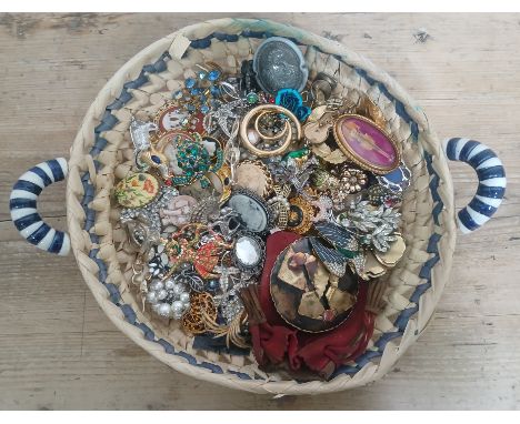 A basket containing a quantity of vintage and costume brooches etc.