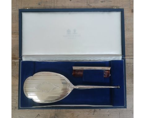 A large silver backed mirror by Mappin &amp; Webb, length 33.5cm, with matching comb and case.