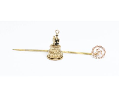 A hallmarked 9ct gold wedding cake charm and an Isle of Man Three Legs stick pin marked 9ct, gross weight 3.6g.