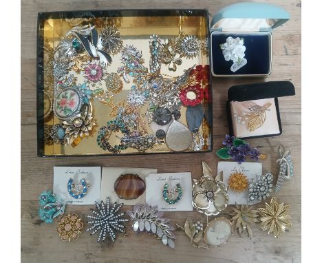 A tray of vintage costume jewellery brooches.