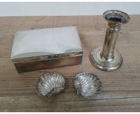 Hallmarked silver comprising a cigarette box, a candlestick and a pair of half clam salts.