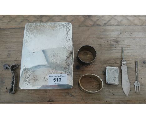 Hallmarked silver comprising a cigarette box and contents including two serviette rings, a vesta, bracelet, pickle fork and a