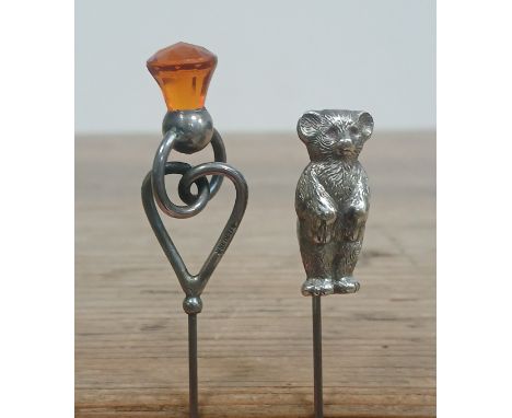 A hallmarked silver teddy bear stick pin and another marked STERLING.