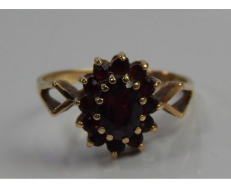 A 9ct gold dress ring, set with garnets in a floral cluster.