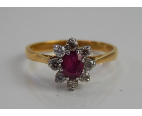 An 18ct gold dress ring, in a floral cluster, with central rubies surrounded by eight tiny diamonds.