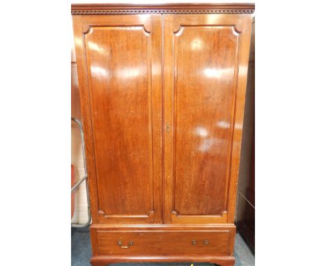 A reproduction mahogany Georgian style hanging single wardrobe, with dentil cornice enclosed by two panel doors and fitted wi