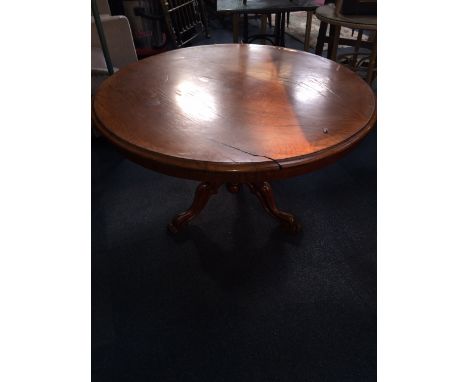 A Victorian oak breakfast table, with circular tilt top, on scroll carved tripod base, 123cm diameter.