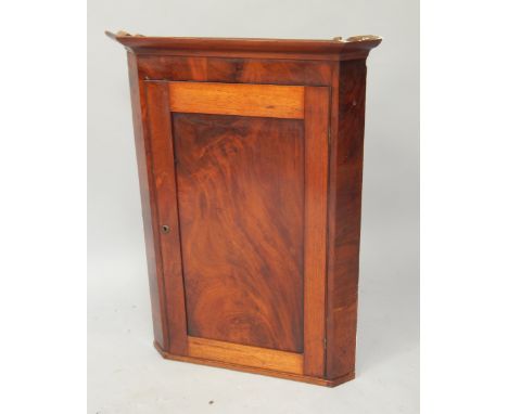 A Georgian flame figured mahogany hanging corner cupboard, enclosed by single panel door and with canted sides, 72cm wide, 98