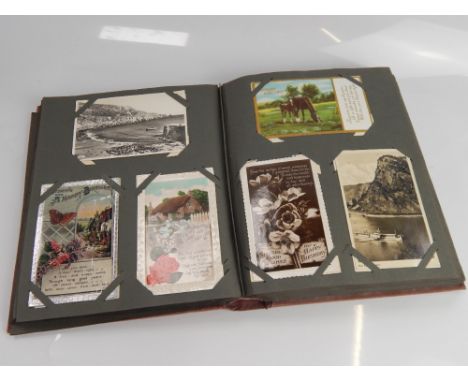 A postcard album, containing a collection of various cards including many humorous, topographical and military interest and s