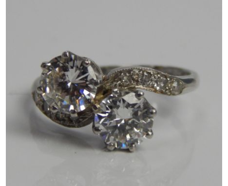 A two stone diamond ring, with two central diamonds on twist shoulders, white metal marked PLAT.
