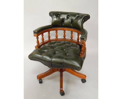 An office swivel chair, in green button upholstered hide.