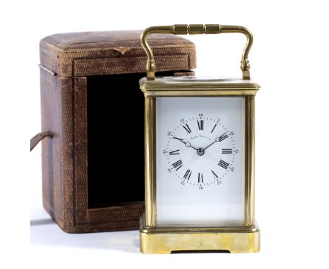 Brass carriage clock with enamel dial, striking mechanism and original red leather travelling case