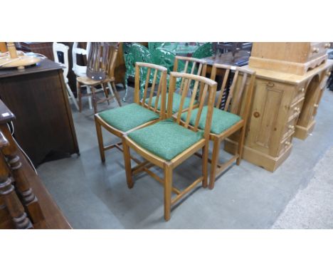 A set of four Ercol oak dining chairs 