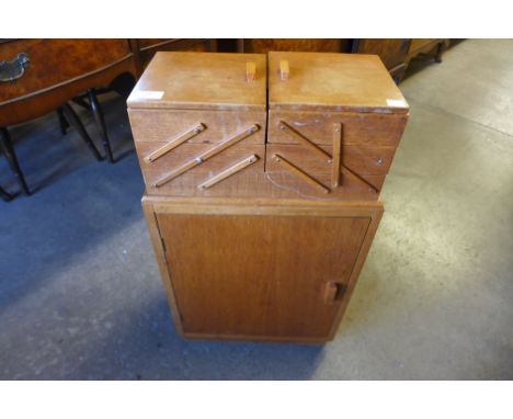 An Art Deco light oak metamorphic sewing cabinet 