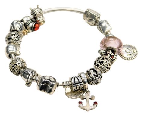 A Pandora bangle, with sixteen charms, on a heart shaped clasp.